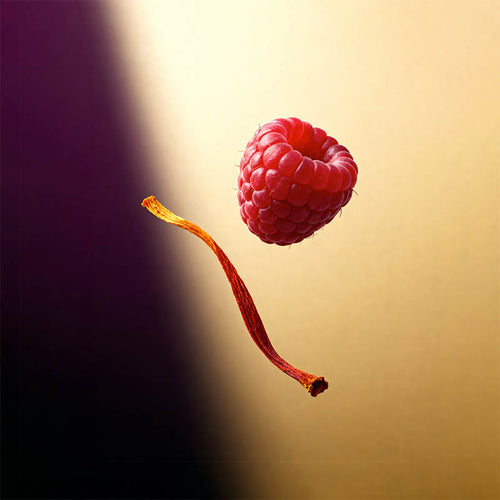 A single red raspberry floating against a warm beige background with a dark purple shadow on the left, alongside a curled orange-red stem.